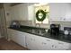Well-lit kitchen featuring white cabinets, tile flooring, and modern appliances at , Hickory, NC 28602