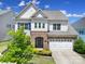 Beautiful two-story home with a stone facade, large windows, and a two-car garage at 1001 Emory Ln, Fort Mill, SC 29708