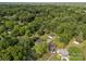 Aerial view of a house in a wooded area with mature trees, a garage, and a long driveway at 1001 Old Charlotte Rd, Concord, NC 28027
