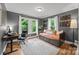 Bedroom featuring a daybed, desk, hardwood floors, multiple windows, and neutral gray paint at 1001 Old Charlotte Rd, Concord, NC 28027