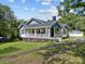 Charming two-story home with blue and white exterior paint, lush landscaping, and a detached garage at 1001 Old Charlotte Rd, Concord, NC 28027