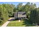 Aerial view of a home with a well-maintained lawn, driveway, and surrounding mature trees at 1002 4Th Ne St, Conover, NC 28613