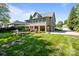Spacious backyard with manicured lawn, stone patio, fire pit, outdoor grill, and basketball hoop by the garage at 1002 4Th Ne St, Conover, NC 28613