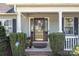Close up of front door featuring beautiful wreath, lovely landscaping, and traditional architectural details at 1002 4Th Ne St, Conover, NC 28613