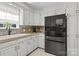 Bright kitchen featuring a black refrigerator, white cabinets, and granite countertops at 1002 4Th Ne St, Conover, NC 28613