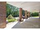 Covered patio area with brick columns overlooks a landscaped backyard with mature trees and plants at 1002 4Th Ne St, Conover, NC 28613