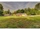Full, large yard with grass, brick house with deck, and detached garage with car at 1009 High Shoals Rd, Lincolnton, NC 28092
