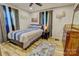 Cozy bedroom with striped bedding, wood floors, a ceiling fan, and decorative wall art at 1009 High Shoals Rd, Lincolnton, NC 28092