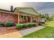 Inviting front porch with rocking chairs, decorative hanging baskets, and manicured landscaping at 1009 High Shoals Rd, Lincolnton, NC 28092