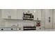 Bright kitchen with stainless steel microwave, white cabinets, subway tile, and modern hardware at 1009 High Shoals Rd, Lincolnton, NC 28092