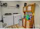 Functional laundry room with washer, dryer, storage shelving, and wood-look flooring at 1009 High Shoals Rd, Lincolnton, NC 28092