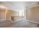 Well-lit hallway with carpeted floors and decorative wooden banister at 10146 Hawkeye Dr # 2, Charlotte, NC 28273