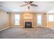 Comfortable living room with soft carpet, fireplace, and a modern ceiling fan at 10146 Hawkeye Dr # 2, Charlotte, NC 28273
