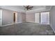 A spacious main bedroom featuring a tray ceiling, a ceiling fan and carpet floors at 10146 Hawkeye Dr # 2, Charlotte, NC 28273