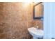 A cozy powder room featuring tiled walls, a pedestal sink, and a decorative mirror at 10146 Hawkeye Dr # 2, Charlotte, NC 28273