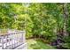 A lovely backyard featuring luscious greenery with a deck and chairs and surrounding nature at 112 Eagle Chase Ln, Troutman, NC 28166