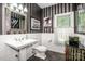 Quaint bathroom featuring unique decor, striped wall paper, decorative mirror, and stained glass window at 112 Eagle Chase Ln, Troutman, NC 28166