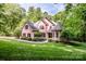 Charming brick home with a well-manicured lawn and lush, mature trees at 112 Eagle Chase Ln, Troutman, NC 28166