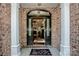 Elegant front door with decorative glass, pillars, and brick wall at 112 Eagle Chase Ln, Troutman, NC 28166