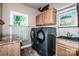 Laundry room features modern washer and dryer, natural lighting, granite counter tops, and cabinetry at 112 Eagle Chase Ln, Troutman, NC 28166