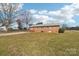 Back exterior view of a one story brick house with a large backyard at 1177 Craigbrow Cir, Chester, SC 29706