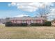 Charming single-story brick home featuring a well-maintained front yard, trimmed hedges, and colorful purple shutters at 1177 Craigbrow Cir, Chester, SC 29706