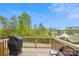 View from wooden balcony overlooking green trees and foliage with a grill at 1206 Keydet Dr, Charlotte, NC 28216