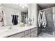 Bathroom with dual sinks, white countertop, dark gray tile shower with glass door, and recessed lighting at 1206 Keydet Dr, Charlotte, NC 28216