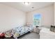 Neutral bedroom featuring a window for natural light, bed with flower patterned bedding, and baby furniture at 1206 Keydet Dr, Charlotte, NC 28216