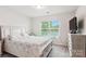 Spacious bedroom featuring a bed with floral patterned bedding, a TV on a dresser and natural light at 1206 Keydet Dr, Charlotte, NC 28216
