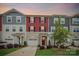 Charming townhome featuring colorful siding, a driveway, manicured lawn, and a covered front porch at 1206 Keydet Dr, Charlotte, NC 28216