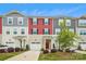 Charming townhome featuring colorful siding, a driveway, manicured lawn, and a covered front porch at 1206 Keydet Dr, Charlotte, NC 28216