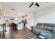 Open concept living room and kitchen with hardwood floors, a modern ceiling fan, and a comfortable gray couch at 1206 Keydet Dr, Charlotte, NC 28216