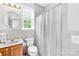 A modern bathroom with tiled walls, a shower curtain, and a round mirror at 1305 Glenview Ln, Rock Hill, SC 29730