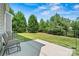 Private backyard featuring a concrete patio, lawn, and fenced perimeter with lush, mature trees providing shade at 142 Wellshire St, Mooresville, NC 28115