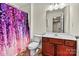 A well-lit bathroom features a floral shower curtain, classic vanity, and a clean, neutral aesthetic at 142 Wellshire St, Mooresville, NC 28115