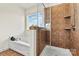 A luxurious bathroom features a separate shower and tub with tile, with natural light from the window at 142 Wellshire St, Mooresville, NC 28115