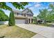 Charming two-story home featuring a stone and siding facade, attached garage, and well-manicured front lawn at 142 Wellshire St, Mooresville, NC 28115