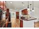 Open kitchen featuring dark cabinets, stainless steel appliances, and a breakfast bar at 142 Wellshire St, Mooresville, NC 28115