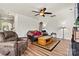 Comfortable living room features a ceiling fan, hardwood floors, and cozy leather furniture with an area rug at 142 Wellshire St, Mooresville, NC 28115
