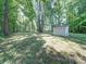 Backyard featuring a storage shed, trees and lawn at 145 Woodview Dr, Statesville, NC 28625