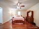 Cozy bedroom featuring a wooden bed frame, ceiling fan and hardwood floors at 145 Woodview Dr, Statesville, NC 28625