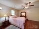 Cozy bedroom with wood floors, ceiling fan, and a decorative bed and a matching dresser set at 145 Woodview Dr, Statesville, NC 28625