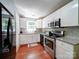Modern kitchen with stainless steel appliances, white cabinets, granite counters, and wood flooring at 145 Woodview Dr, Statesville, NC 28625
