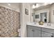 Well-lit bathroom featuring dual sinks, a shower with a floral curtain, and neutral decor at 1497 Striped Bass Ln, Clover, SC 29710