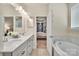 Bright bathroom featuring a double vanity, soaking tub, and doorway to a bedroom at 1497 Striped Bass Ln, Clover, SC 29710