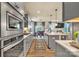 Open kitchen layout with modern appliances, gray cabinetry, and views into the living room at 1497 Striped Bass Ln, Clover, SC 29710