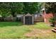 Backyard shed offers additional storage space, complementing the well-manicured lawn and wooden fence at 1509 Wiltshire Rd, Salisbury, NC 21844