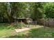 Shaded backyard with a fence and a small structure providing ample privacy and space at 1509 Wiltshire Rd, Salisbury, NC 21844