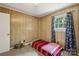 Bedroom with wood paneling, a single bed, and a window with blue curtains at 1975 Peace Rd, Fort Mill, SC 29715